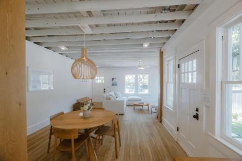 a dining room and living room with a wooden ceiling at Villa Marguerita by WB Abodes in Wrightsville Beach