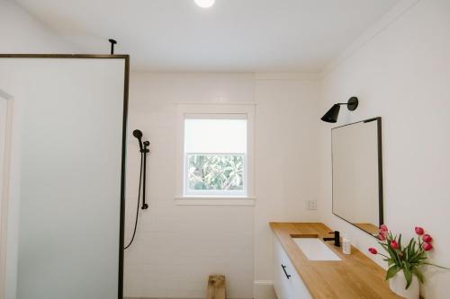 a bathroom with a sink and a mirror at Villa Marguerita by WB Abodes in Wrightsville Beach