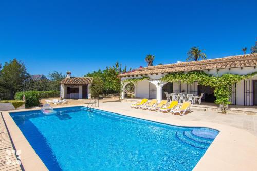 una piscina con sillas y una casa en Villa Fumepacoon by Abahana Villas, en Benissa