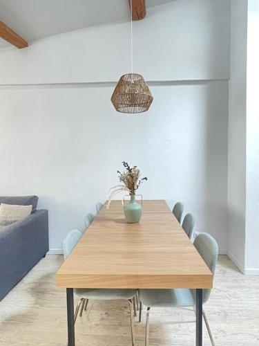 - une salle à manger avec une table en bois et un vase dans l'établissement Le Refuge du Port, parking privé gratuit, à La Ciotat