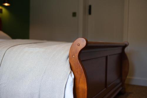 a wooden foot board of a bed with a white mattress at The Fox & Hounds Inn in Dorchester