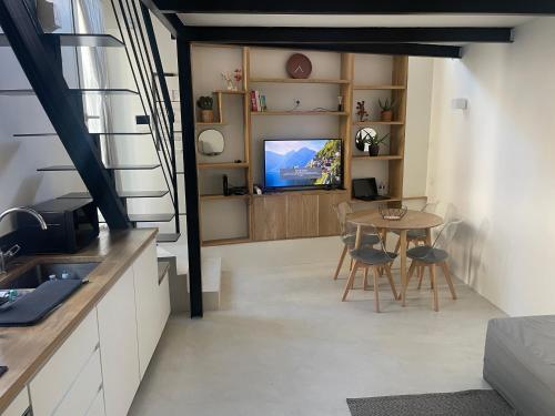 une cuisine et une salle à manger avec une table et une télévision dans l'établissement le roche-terrail, à Marseille