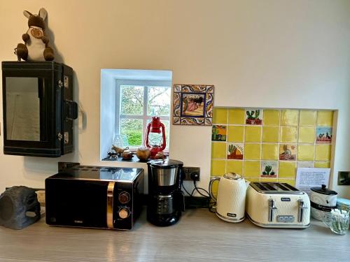 a kitchen counter with a microwave and some appliances at The Milking Parlour in Collinstown