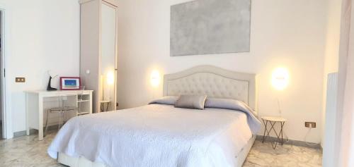 a white bedroom with a white bed and a desk at Angela's Apartment. Elegant two bedroom house in Irsina in Irsina
