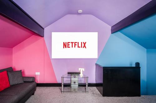 a living room with a couch and a sign that reads netflix at Social Media Adventure - 3 Bedroom - City Centre - Doncaster in Balby