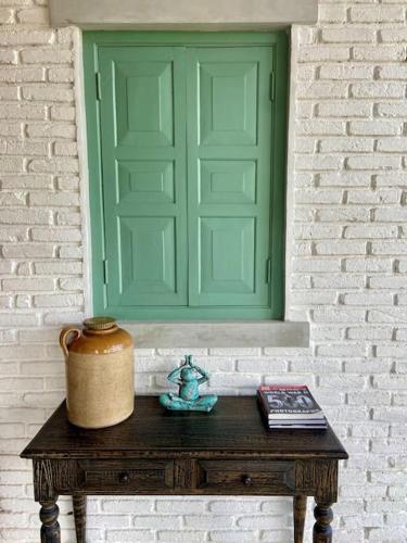 a table with a green window and a pot on it at Linwewa Villa, Sigiriya in Sigiriya