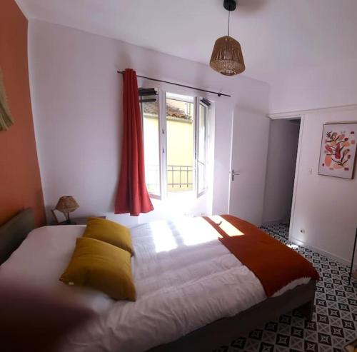 une chambre avec un grand lit avec une fenêtre dans l'établissement Le Petit Ecusson à la Cathédrale, à Nîmes