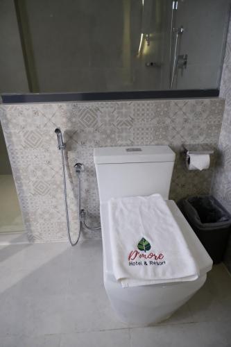 a bathroom with a toilet with a towel on it at D'more Kuakata Hotel & Resort in Kuākāta