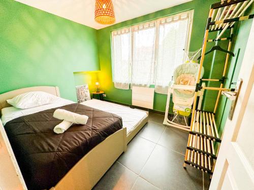 - une chambre avec un lit aux murs verts dans l'établissement Anh K - TiamConciergerie - DISNEY - Meaux Centre, à Meaux