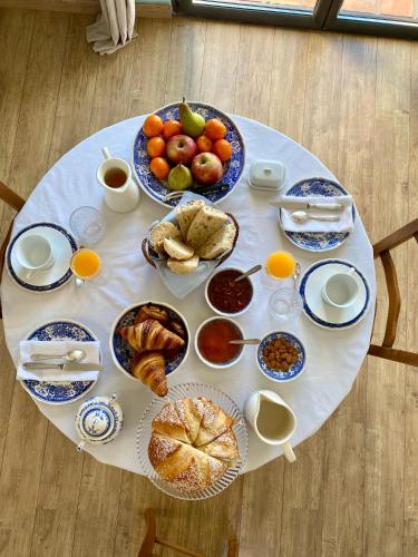 une table blanche avec des assiettes de nourriture dans l'établissement Maison Pivoine, à Sault