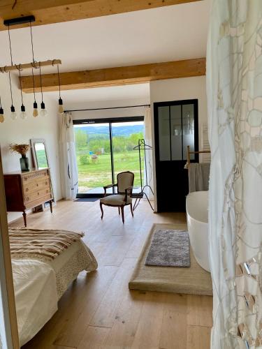 une chambre avec un lit et une salle de bain avec baignoire dans l'établissement Maison Pivoine, à Sault