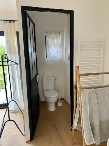 une salle de bain avec des toilettes blanches dans une chambre dans l'établissement Maison Pivoine, à Sault