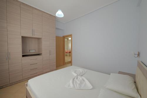 DANA HOTEL APARTMENTs في سارنده: غرفة نوم بسرير أبيض وتلفزيون