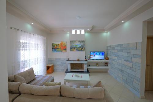 DANA HOTEL APARTMENTs في سارنده: غرفة معيشة مع أريكة وتلفزيون