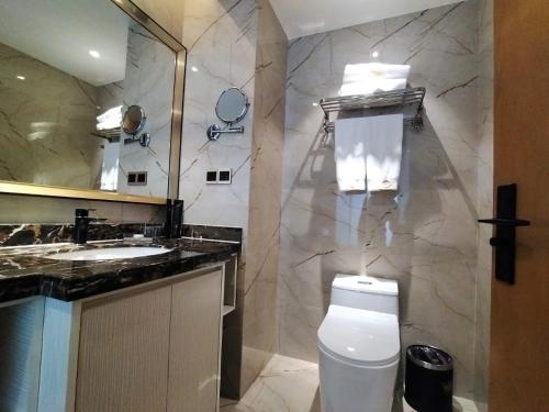 a bathroom with a white toilet and a sink at The Venetian Hotel in Lusaka