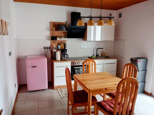 uma cozinha com uma mesa de madeira e um frigorífico rosa em Ferien im Brombachtal em Brombachtal