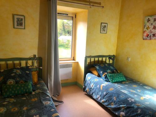 1 dormitorio con 2 camas junto a una ventana en Les Trégorines-Squibernévez, en Pédernec