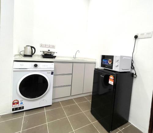 a kitchen with a washing machine and a refrigerator at Cozy home in city center with free parking -1B in Kuala Lumpur