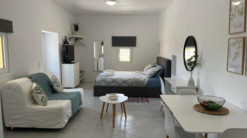ein Wohnzimmer mit einem Bett, einem Sofa und einem Tisch in der Unterkunft Elia Houses - Traditional House With Backyard in Kastrisiánika