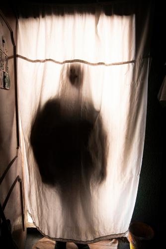a person is standing in front of a curtain at بنك الاتحاد in Nāţifah