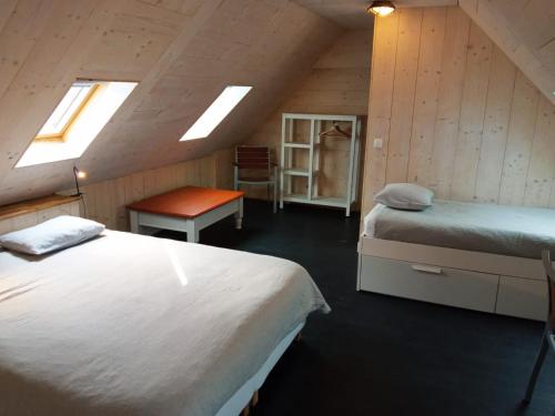 1 dormitorio en el ático con 2 camas y mesa en Chez Fanch en Lampaul
