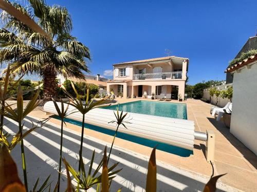 une maison avec une piscine en face d'une maison dans l'établissement La Villa verdoyante, à Baillargues