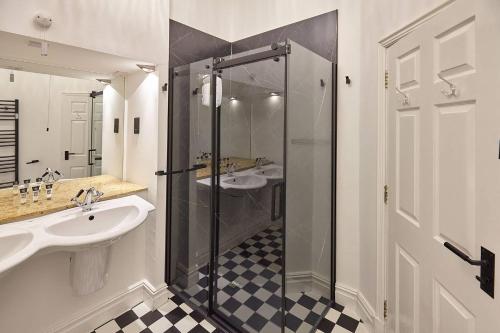 a bathroom with two sinks and a glass shower at Sea Forever Oceanfront Home Perfectly Saltburn in Saltburn-by-the-Sea