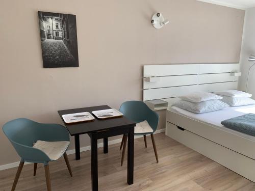 a bedroom with a table and two chairs and a bed at Studiový apartmán V Zahradě in Police nad Metují