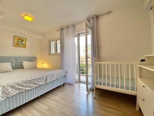 1 dormitorio con 1 cama y puerta corredera de cristal en Apart Hotel Apple Cat Montenegro KO Bijela, en Bijela