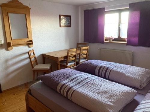 1 Schlafzimmer mit 2 Betten, einem Tisch und Stühlen in der Unterkunft Ferienwohnung auf dem Erlebnisreiterhof Kreipl in Grattersdorf