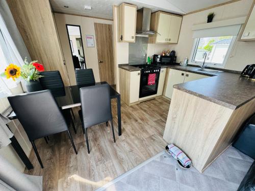a kitchen with a table and chairs and a counter top at Rosa - Bournemouth Holiday Home in Wimborne Minster