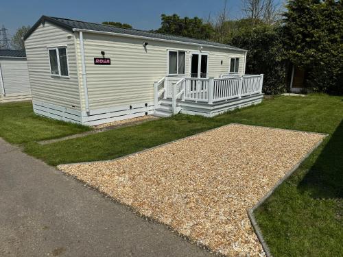 a white building with a porch and a yard at Rosa - Bournemouth Holiday Home in Wimborne Minster