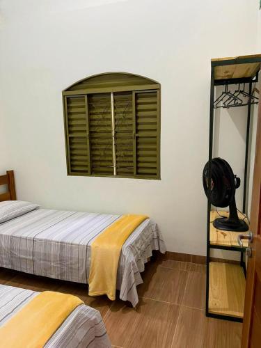 a bedroom with two beds and a window at HospedaAurora Casa 3 quartos com ar in Manhã