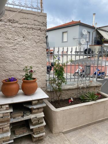 two pots sitting on a bench next to a building at Ambelos Skala in Mytilini