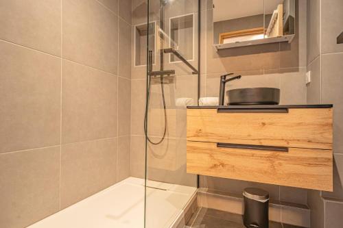 une salle de bain avec une douche en verre avec un lavabo dans l'établissement Chamois Blanc Rosières- bright 1 bed apartment with amazing views, à Chamonix-Mont-Blanc