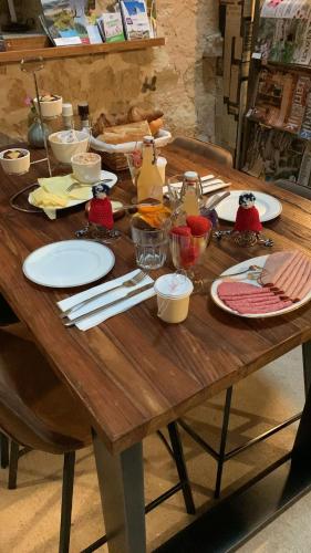 SerécourtにあるMaison Le Haut Féeの皿と食器が置かれた木製のテーブル