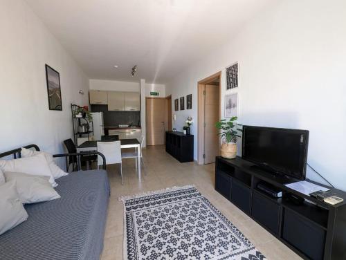 een woonkamer met een bed en een televisie en een keuken bij Central Apartment, Is-Swieqi in Is-Swieqi
