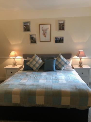 a bedroom with a bed with two lamps on tables at Glenmoriston Arms Hotel in Invermoriston