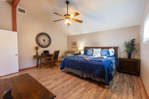Un dormitorio con una cama, un escritorio y un ventilador de techo. en The Hideout at Hills Haven, en Wimberley