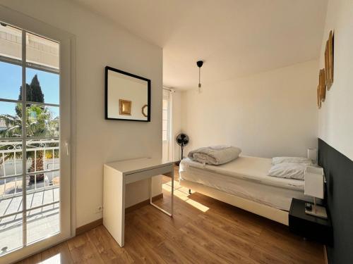 - une chambre avec un lit, un bureau et une fenêtre dans l'établissement La Villa verdoyante, à Baillargues