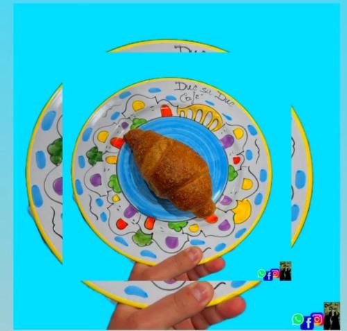 a person holding a plate with a piece of food on it at B&B Due Su Due Holiday in Vietri sul Mare