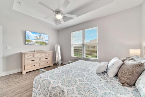 um quarto com uma cama e uma ventoinha de tecto em The Perdido Cottage em Pensacola