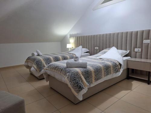 een slaapkamer met 2 bedden en een bank bij Guesthouse "PELIVANI" in Berat