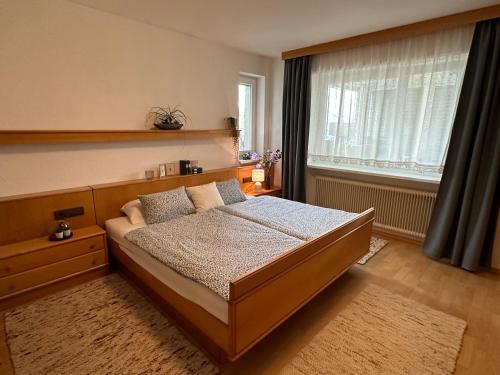 een slaapkamer met een bed en een raam bij Kraft tanken in grüner Oase mit großem Wohnraum und riesigem Garten in Dornbirn