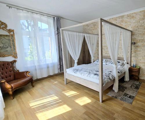 a bedroom with a canopy bed and a window at Sopot Spa Apartament in Sopot