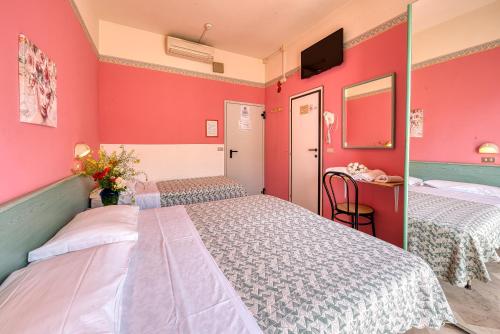 duas camas num quarto com paredes vermelhas em Hotel Sabbia d'Oro em Rimini