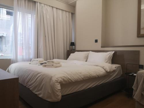 een slaapkamer met een groot bed met handdoeken erop bij Athenian Apartments, Syntagma square #6 in Athene