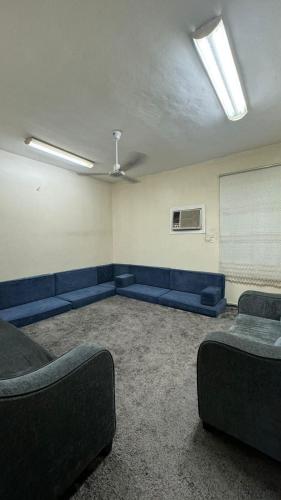 Room and Bath Only في Az Zāhir: غرفة انتظار مع كنب ازرق وطاولة بيضاء
