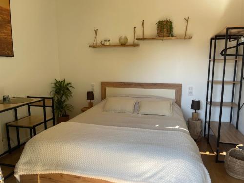 Chambre d’hôte indépendante في لاكانو: غرفة نوم مع سرير ورفوف على الحائط