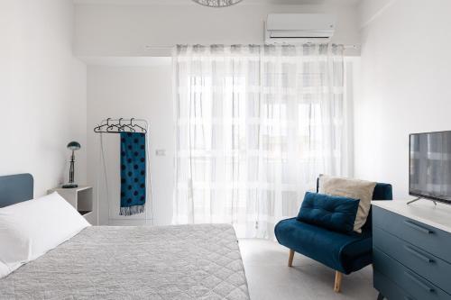 a bedroom with a bed and a blue chair at Freshwater Pirates in Gaeta